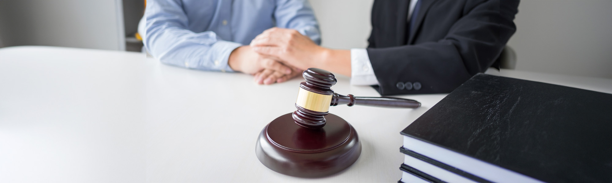 Man and woman at conference table speaking with lawyer while holding hands. Tampa Probate Lawyers concept image