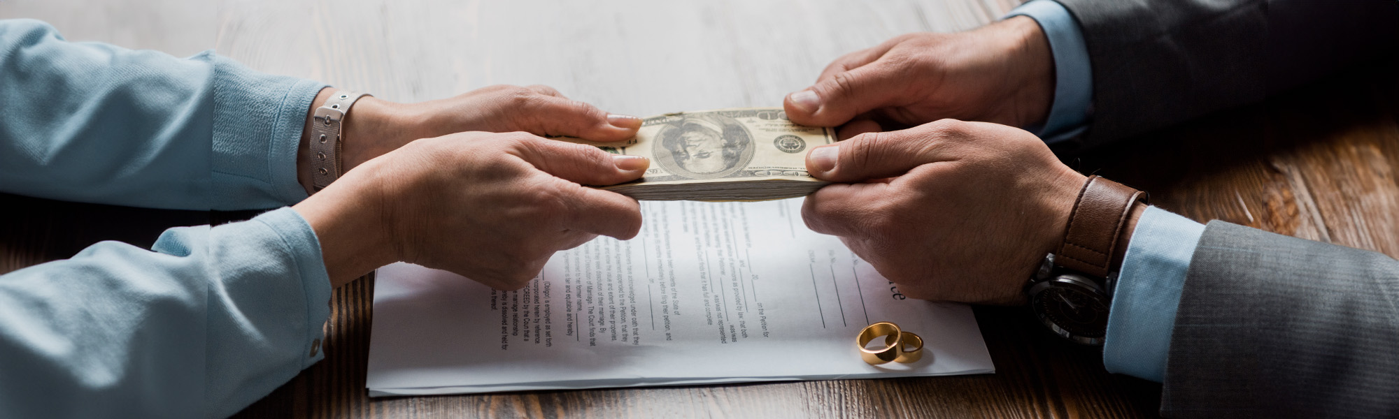 lawyer and client holding dollar banknotes above divorce decree
