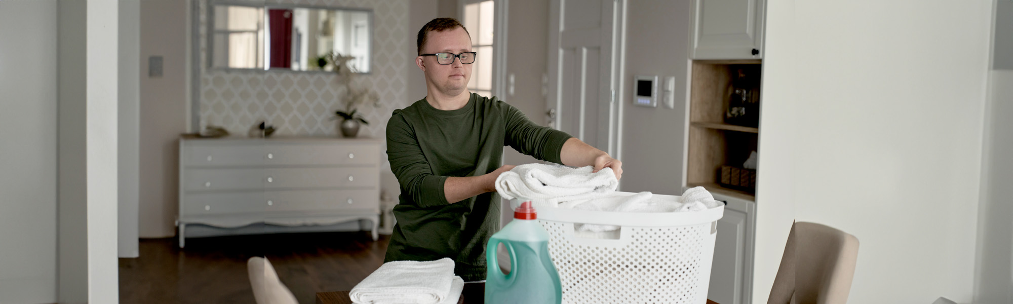 man with down syndrome folding laundry