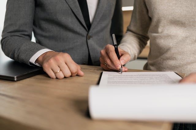 people in suits signing documents