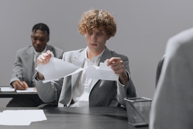 man tearing document in half
