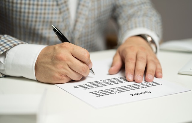 man signing legal document