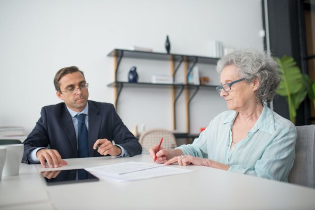 man and woman sitting at table with documents